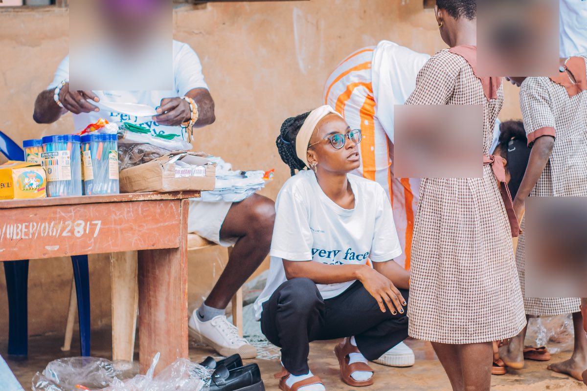 Handing school supplies to a child during a welfare outreach